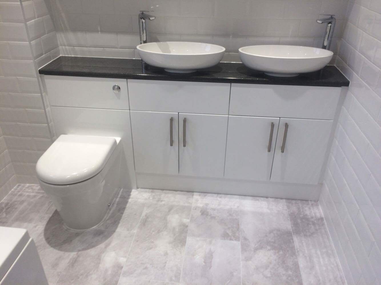 Completed bathroom with twin countertop basins and fitted storage